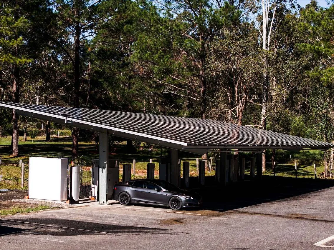 Commercial solar carport with EV charging and a parked Tesla