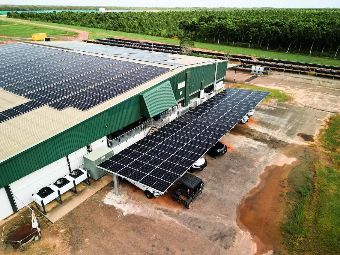 Commercial solar carport beside a solar-clad shed, aerial view